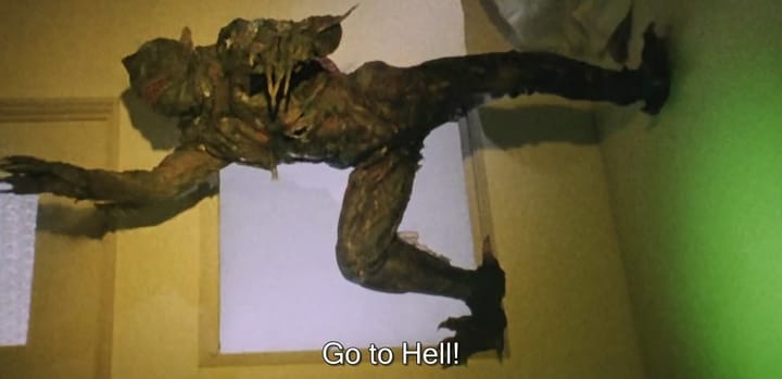 A monster that looks suspiciously similar to the Create from the Black Lagoon stands sideways on the wall of a room with yellow and green lighting. The subtitle says "Go to Hell!"